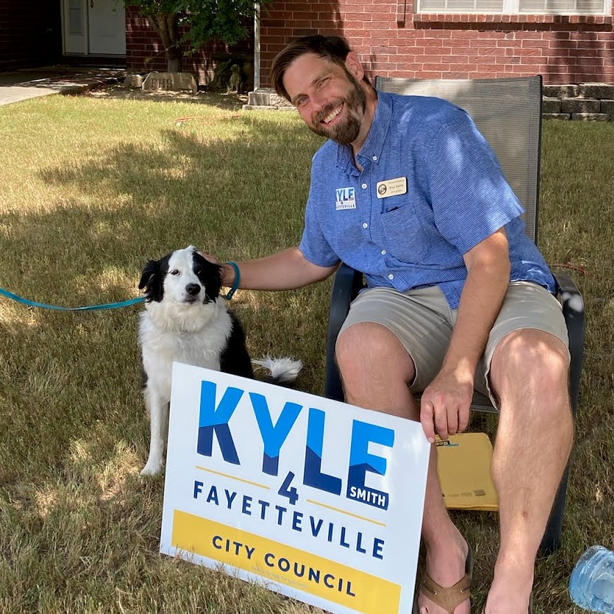 Kyle canvassing with a dog and campaign yard sign